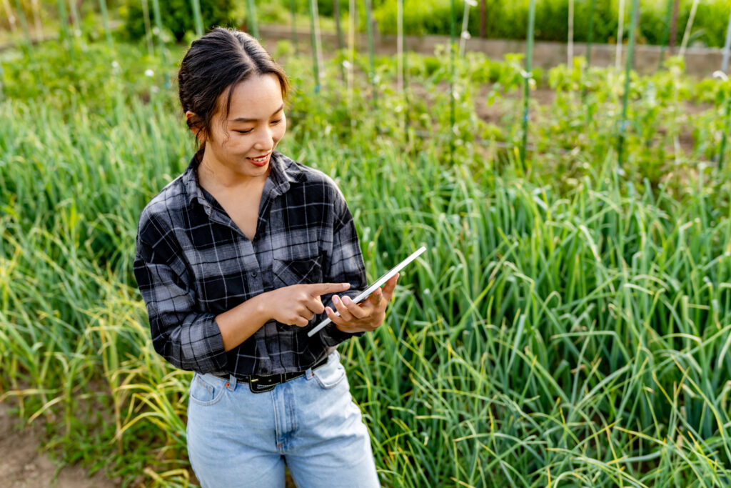 Shot of a young woman using a digital tablet while inspecting crops on a farm